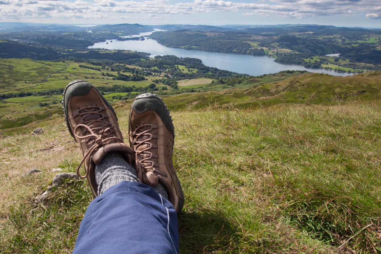 Relaxing and taking in the stunning view from the summit of Wansfell Pike looking south towards Lake Windemere in the Lake district, Northern England