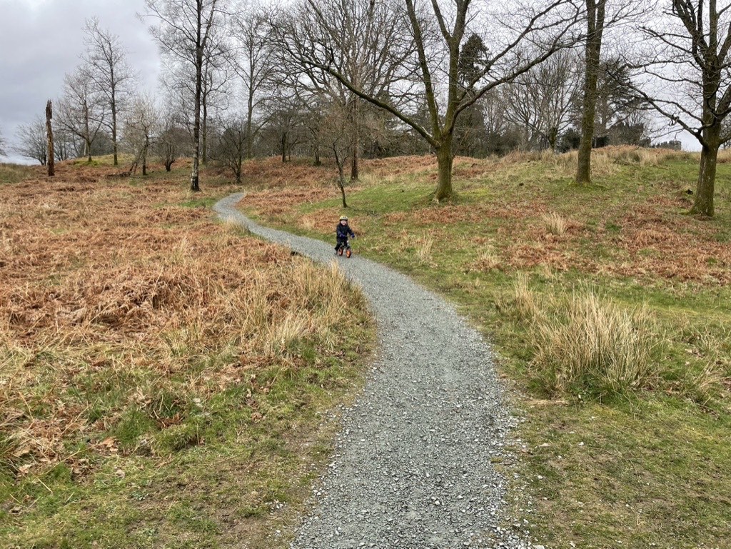 Little boy on a bike exploring the Grounds at Wray Castle 