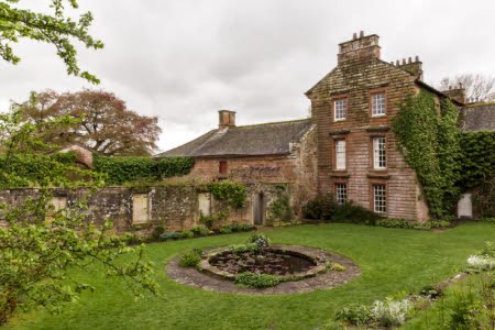 The Lily pond with the manor house in the background at Acorn Bank, Cumbria